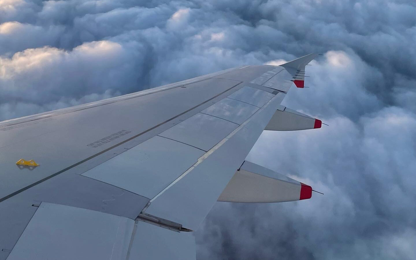 Airplane Wing with clouds in the background.