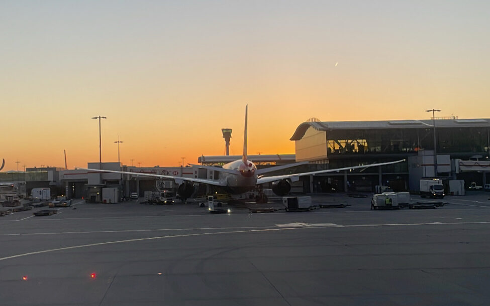 Plane parked at London Heathrow Terminal 5 with Sunset in background