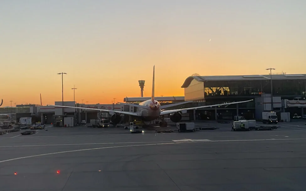 Plane parked at London Heathrow Terminal 5 with Sunset in background